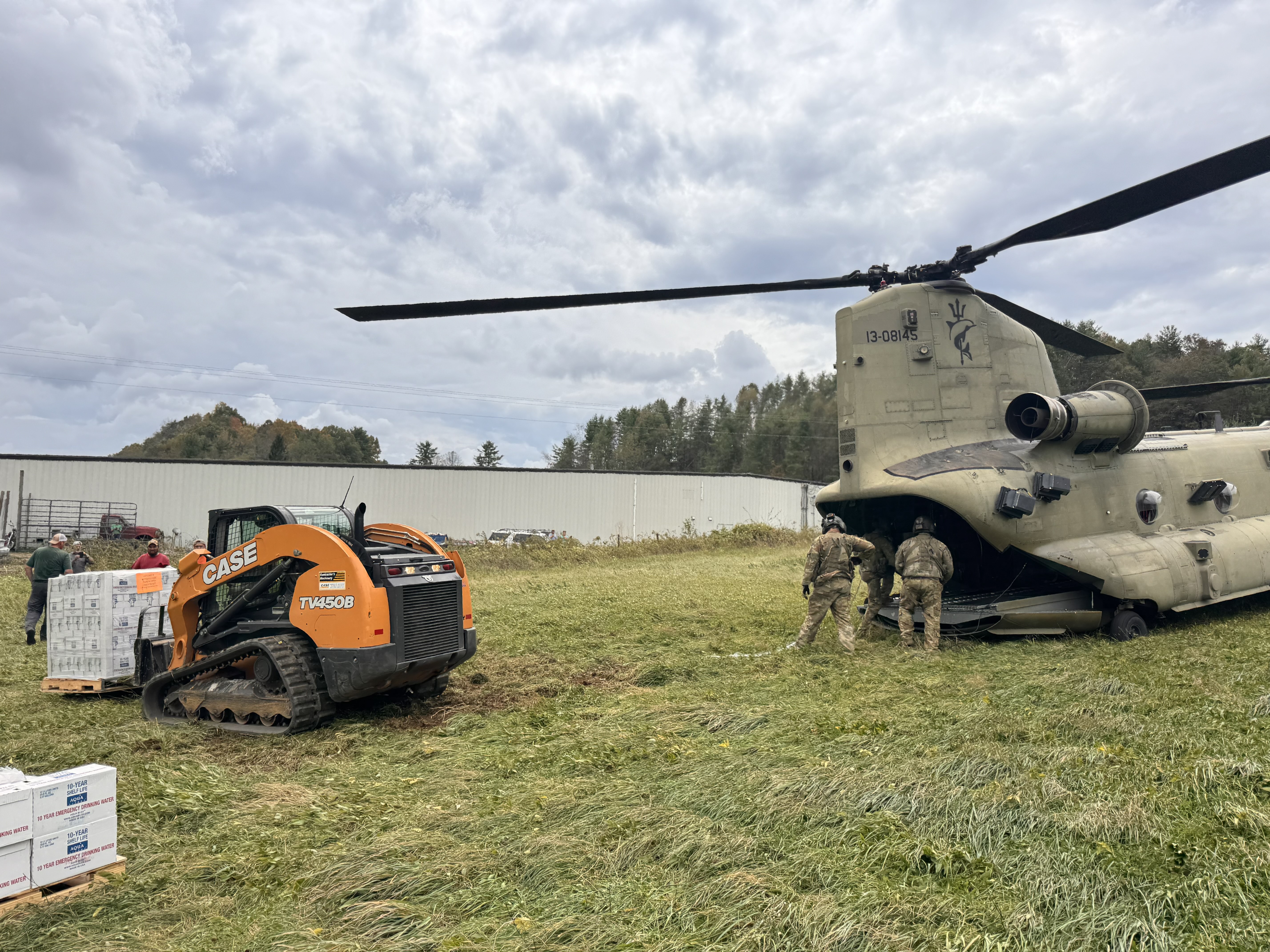 A forklift moves supplies from the back of a helicopter.