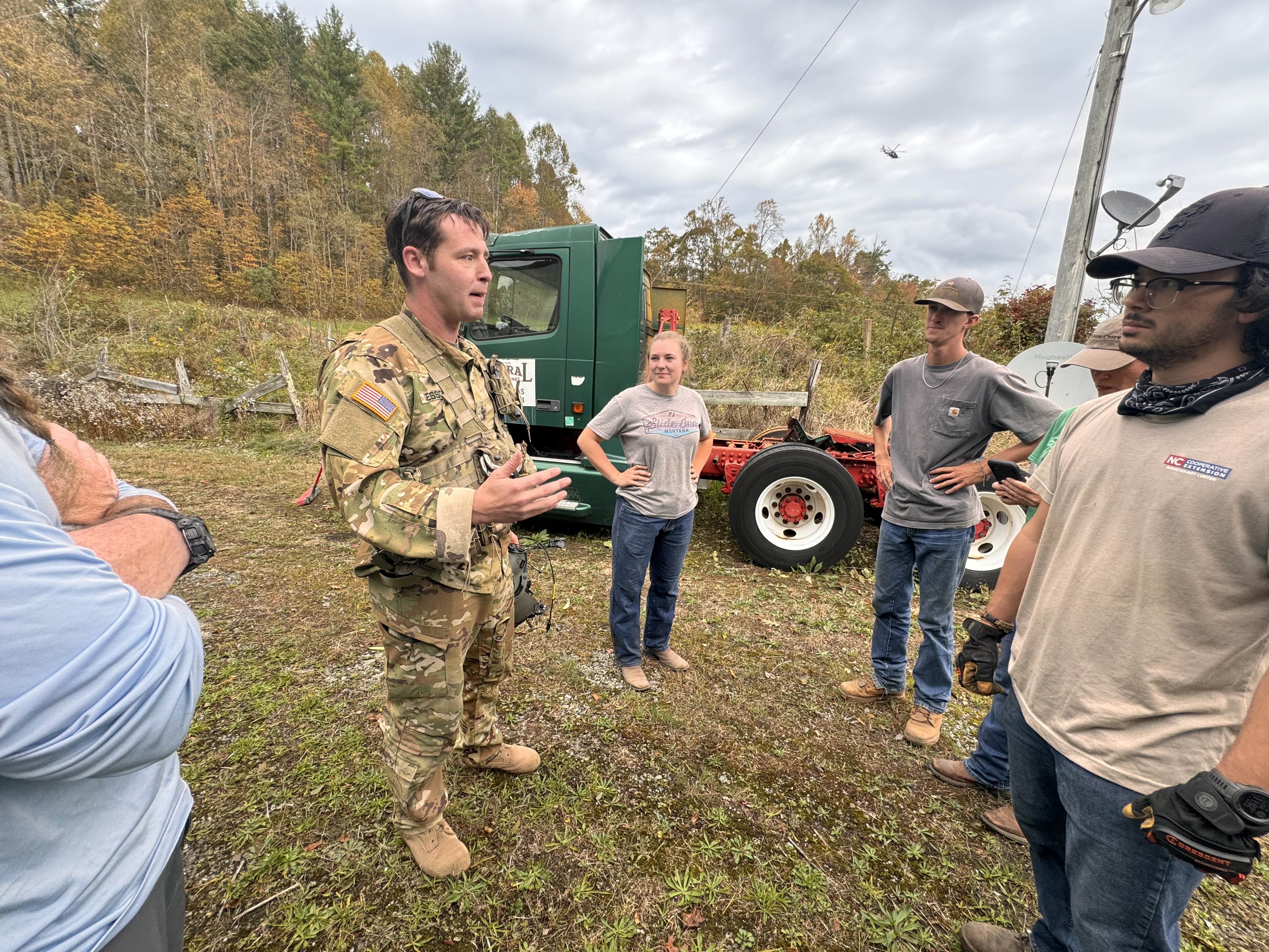 Volunteers and N.C. Cooperative Extension work with a man in uniform to load supplies.